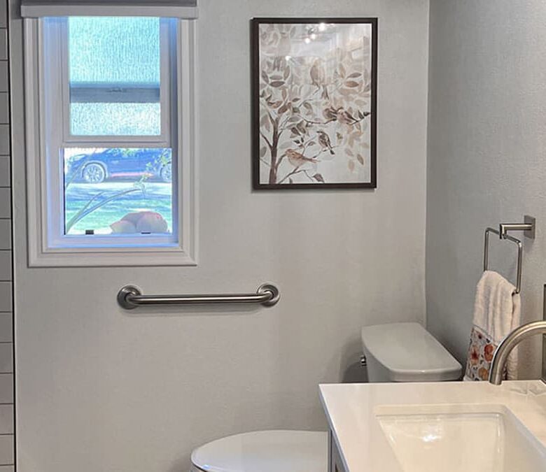Contemporary bathroom update with white vanity, brushed nickel fixtures, subway tile shower, and framed mirror